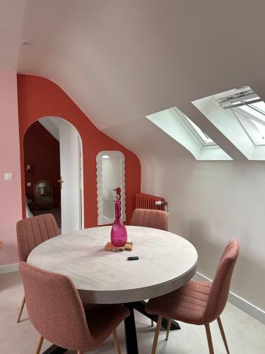 a dining room with a table with chairs and a vase on it at Grand Appartement ultra moderne Plein Centre, plage à pieds, avec parking in Concarneau