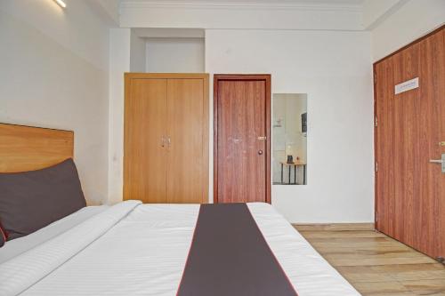 a bedroom with a large bed and wooden cabinets at Super Townhouse Kachnar House Vikas Nagar in Lucknow