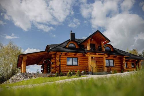 a log cabin on a hill with a sky at Galicyjska Chata in Kwiatonowice