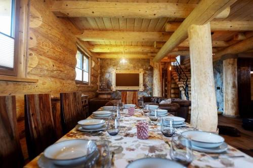 a dining room with a long table with plates and glasses at Galicyjska Chata in Kwiatonowice