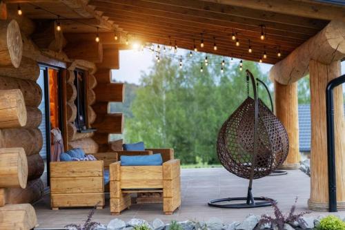 a patio with a swing and a chair on a porch at Galicyjska Chata in Kwiatonowice