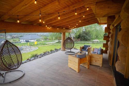 a porch with a swing and a couch on a patio at Galicyjska Chata in Kwiatonowice
