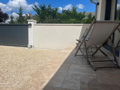 a chair sitting on a patio next to a fence at Charmante maison à louer in Saint-Cyr-sur-Loire