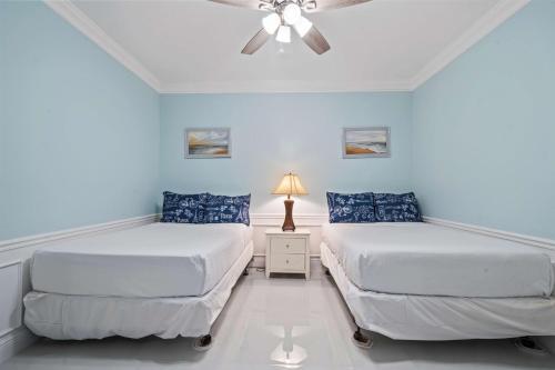 two beds in a room with a ceiling fan at Seaescape in Orlando