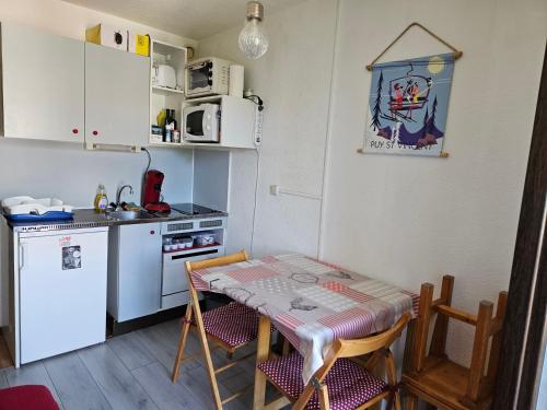 une petite cuisine avec une table et une table et des chaises dans l'établissement studio 4 pers Puy-Saint-Vincent 1700, à Puy-Saint-Vincent