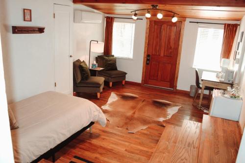 a bedroom with a bed and a chair and a wooden floor at Dreamcatcher B&B in Taos