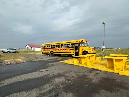 a yellow school bus parked in a parking lot at Cave Cabins in Hella