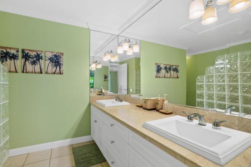 une salle de bain avec deux lavabos et un grand miroir dans l'établissement VOK29 Hawaiiana 3br 3ba Villa of Kamalii, AC, Pool, à Princeville