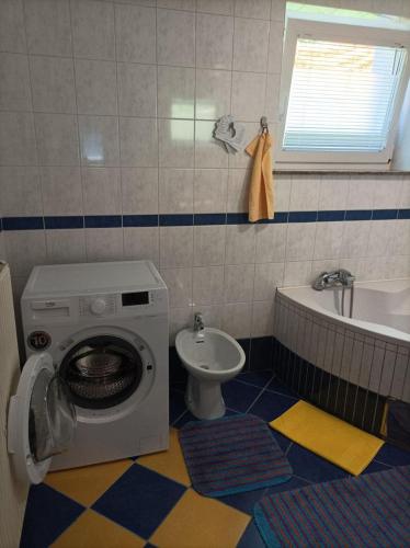 a bathroom with a washing machine and a sink at RELAX in Kamnik