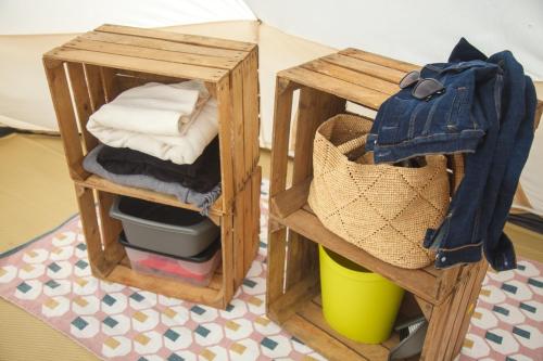 two wooden boxes with towels and a basket on a floor at Glamping Meadow Bell Tent in Stithians