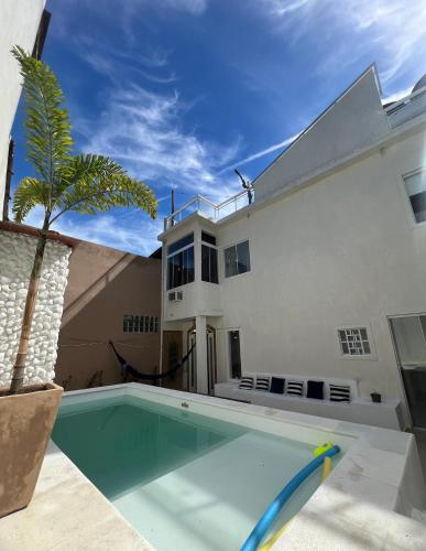 a swimming pool in front of a house at Casa com piscina, churrasqueira e terraço com vista pro mar! in Mangaratiba