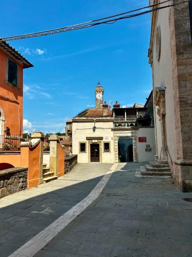 an alley with a building with a clock tower at Palazzo Palloni: Piano Nobile in Sorano