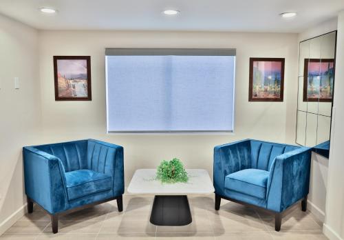 two blue chairs and a table in a waiting room at Baymont by Wyndham Tucson Airport in Tucson