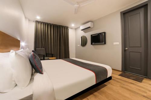 a hotel room with a bed and a television at Super Townhouse 158 Near Netaji Subhash Marg Near Appu Ghar in Gurgaon