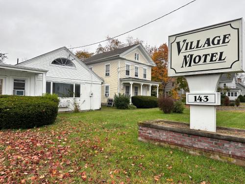 a village motel sign in front of a house at Village Motel in Clinton