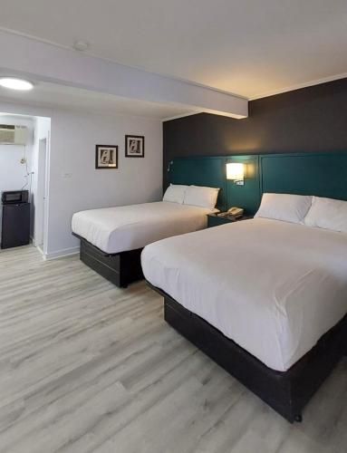 two beds in a hotel room with two beds at Village Motel in Clinton