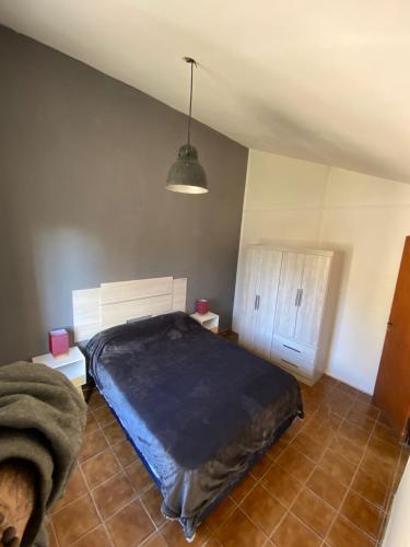 une chambre avec un grand lit et une lampe dans l'établissement alojamiento en mendoza, à Godoy Cruz