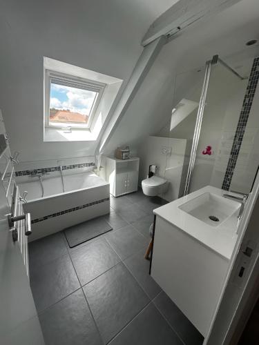 a white bathroom with a tub and a sink at Maison vue Rivière du Bono 8 personnes in Le Bono