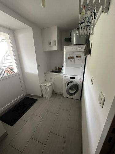 a small kitchen with a washer and dryer in it at Maison vue Rivière du Bono 8 personnes in Le Bono