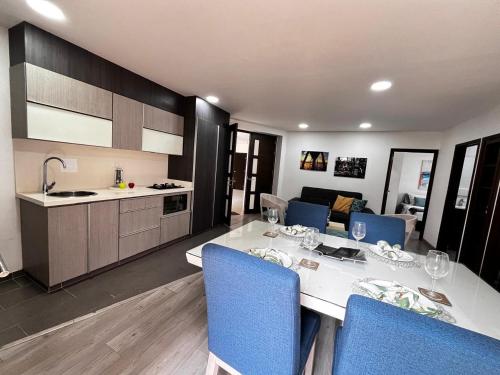 cocina y comedor con mesa blanca y sillas azules en RUITOQUE CONDOMINIO Apartamento, en Piedecuesta