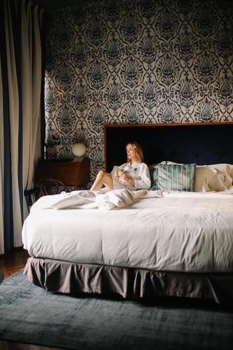 a woman sitting on top of a bed at Pug Seal Polanco Anatole France in Mexico City