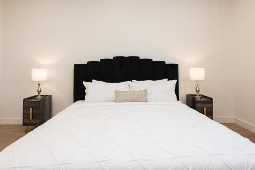 a bedroom with a large white bed with two lamps at Stylish Apartments in Glendale with Free Parking in Glendale