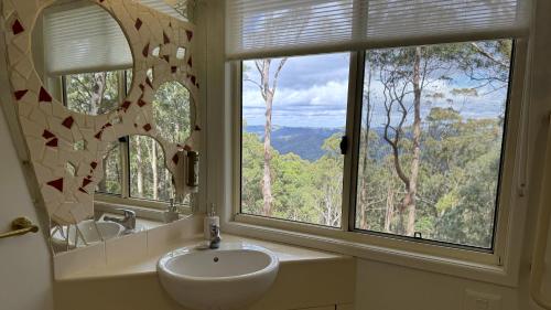 a bathroom with a sink and a large window at Heaven in the Hills Retreat in Maleny