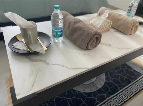 a table with a towel and a bottle of water at Corniche Street - Extremely Unique Room in Abu Dhabi