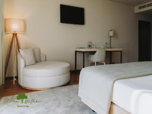 a bedroom with a bed and a chair and a desk at Olive Nature Hotel & SPA - Quinta Valle de Passos in Valpaços