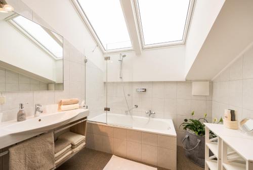 a bathroom with a sink and a tub and a skylight at Haus Stablerkrämer in Maria Alm am Steinernen Meer