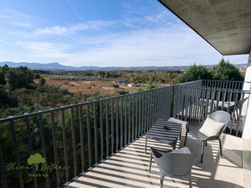 a balcony with chairs and a view of the mountains at Olive Nature Hotel & SPA - Quinta Valle de Passos in Valpaços