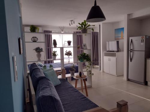 a living room with a blue couch and a refrigerator at Apartamento Costa del Sol in Mar del Plata