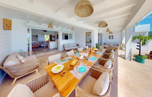 a dining room with a long wooden table and chairs at SUNSEEKER SXM - Luxury Guest House 4 stars - Amazing Sea View Pinel - Tintamarre in Orient Bay
