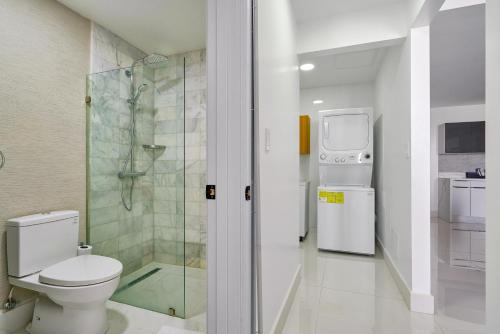 a bathroom with a toilet and a walk in shower at Monaco Residences Piantini in Santo Domingo