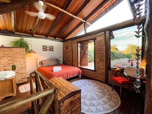 Un dormitorio con una cama roja y una ventana. en Casa de Hospedes Chalé Rustico com Banheira e Piscina Privativa a 1h de SP Espaço Totalmente Privativo, en Atibaia