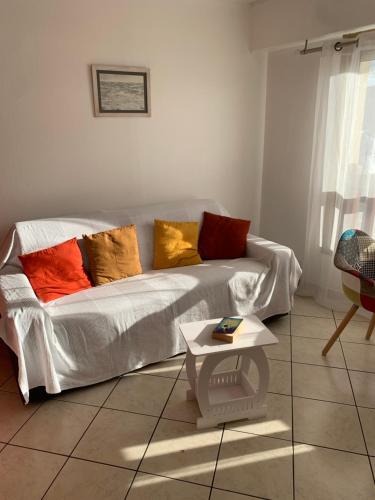 - un salon avec un canapé blanc et des oreillers colorés dans l'établissement Edith, à Trouville-sur-Mer
