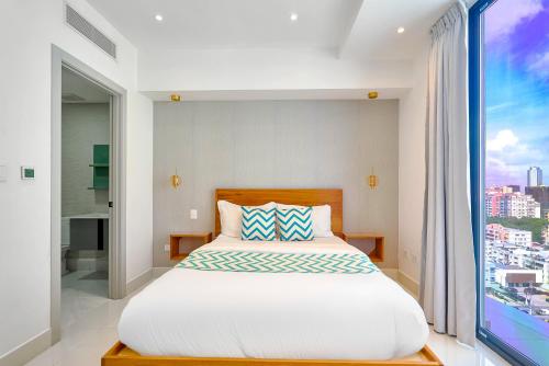 a bedroom with a bed and a large window at Monaco Residences Piantini in Santo Domingo