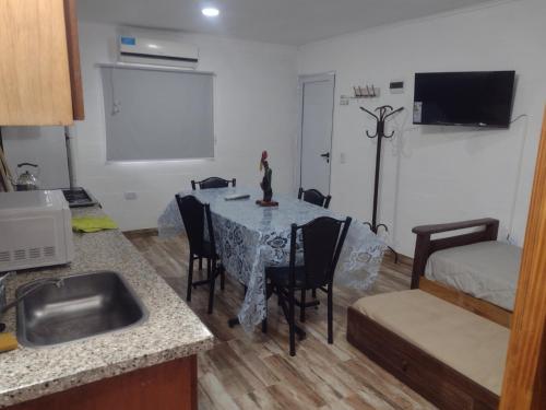 a kitchen with a table and chairs and a room at Cabañas y Bungalow " La Comarca" in Concepción del Uruguay