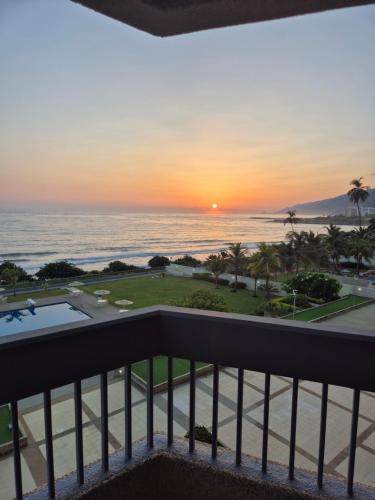 a view from the balcony of the ocean at sunset at Auromar in Caraballeda