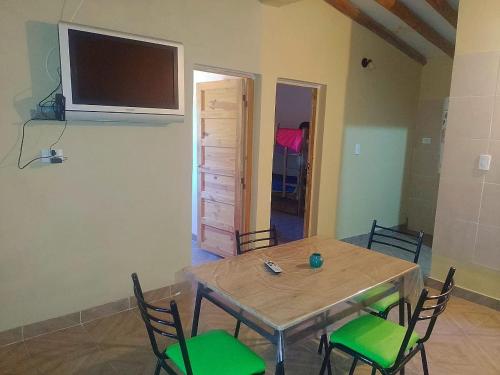 a dining room with a table and chairs with a television on the wall at Casas de montañas in Uspallata