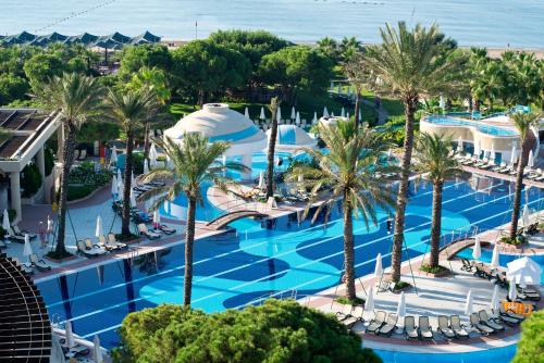 an aerial view of a resort pool with palm trees at Limak Atlantis Deluxe Hotel Belek in Belek