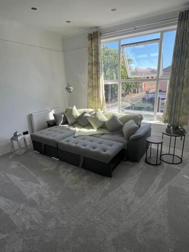a living room with a couch and a large window at Central Two-three bedroom Beach town maisonette in Southsea