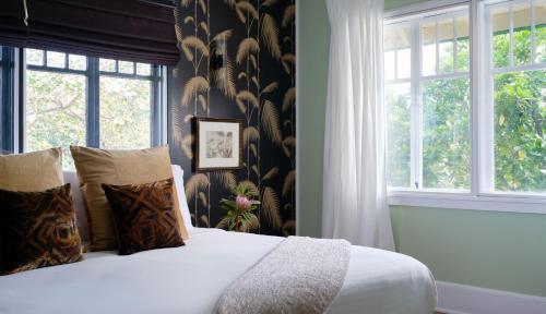a bedroom with a bed with a large window at The Historic Wailuku Inn Maui in Wailuku