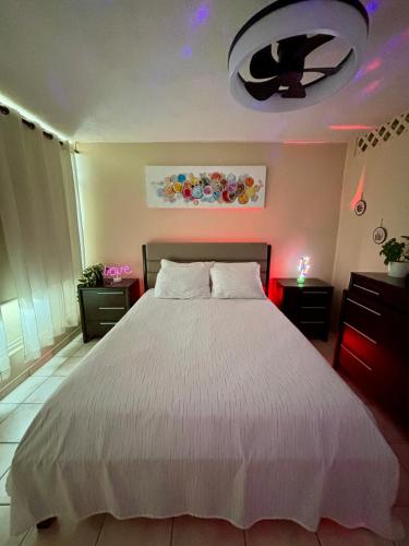 a bedroom with a white bed and a ceiling fan at Downtown Beachfront Isla Verde Luxury Apartment in San Juan