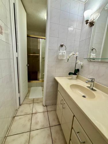 a white bathroom with a sink and a shower at Downtown Beachfront Isla Verde Luxury Apartment in San Juan