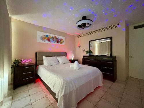 1 dormitorio con cama blanca y espejo en Downtown Beachfront Isla Verde Luxury Apartment, en San Juan