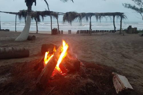 a fire pit on a beach with the ocean in the background at Villa Playa Encantada in Barra de Tuxpan
