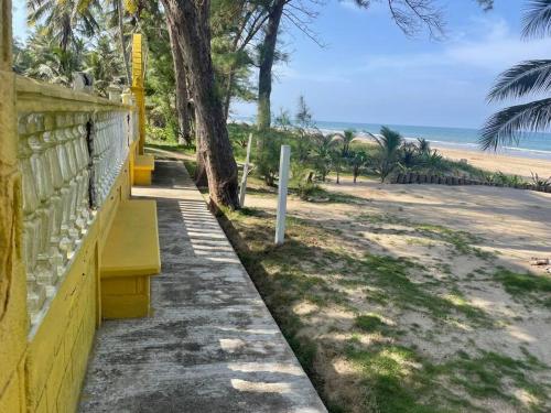 a yellow bench sitting next to a sandy beach at Villa Playa Encantada in Barra de Tuxpan