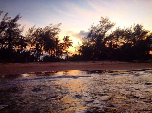 a sunset on a beach with a body of water at Villa Playa Encantada in Barra de Tuxpan