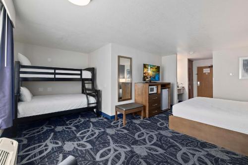a bedroom with two beds and a desk with a mirror at Best Western Plus Twin Falls Hotel in Twin Falls